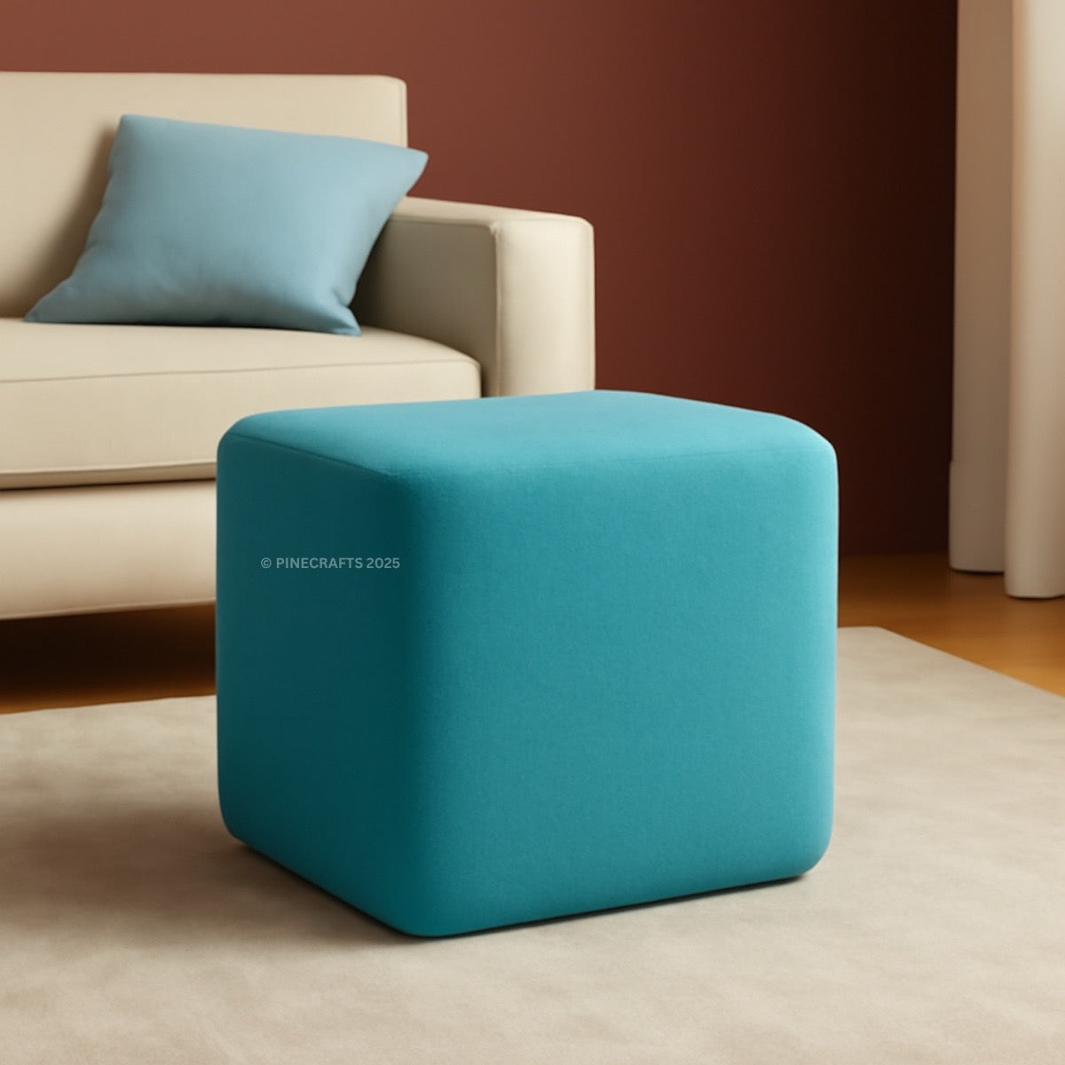 Blue cube-shaped ottoman in a room with a beige sofa and blue pillow.