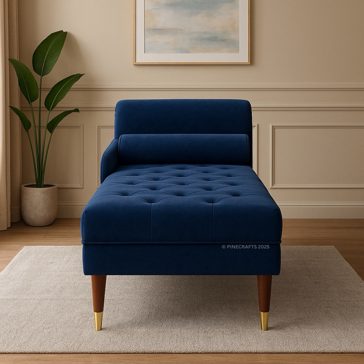 Blue tufted chaise lounge in a room with a plant and framed picture on the wall.