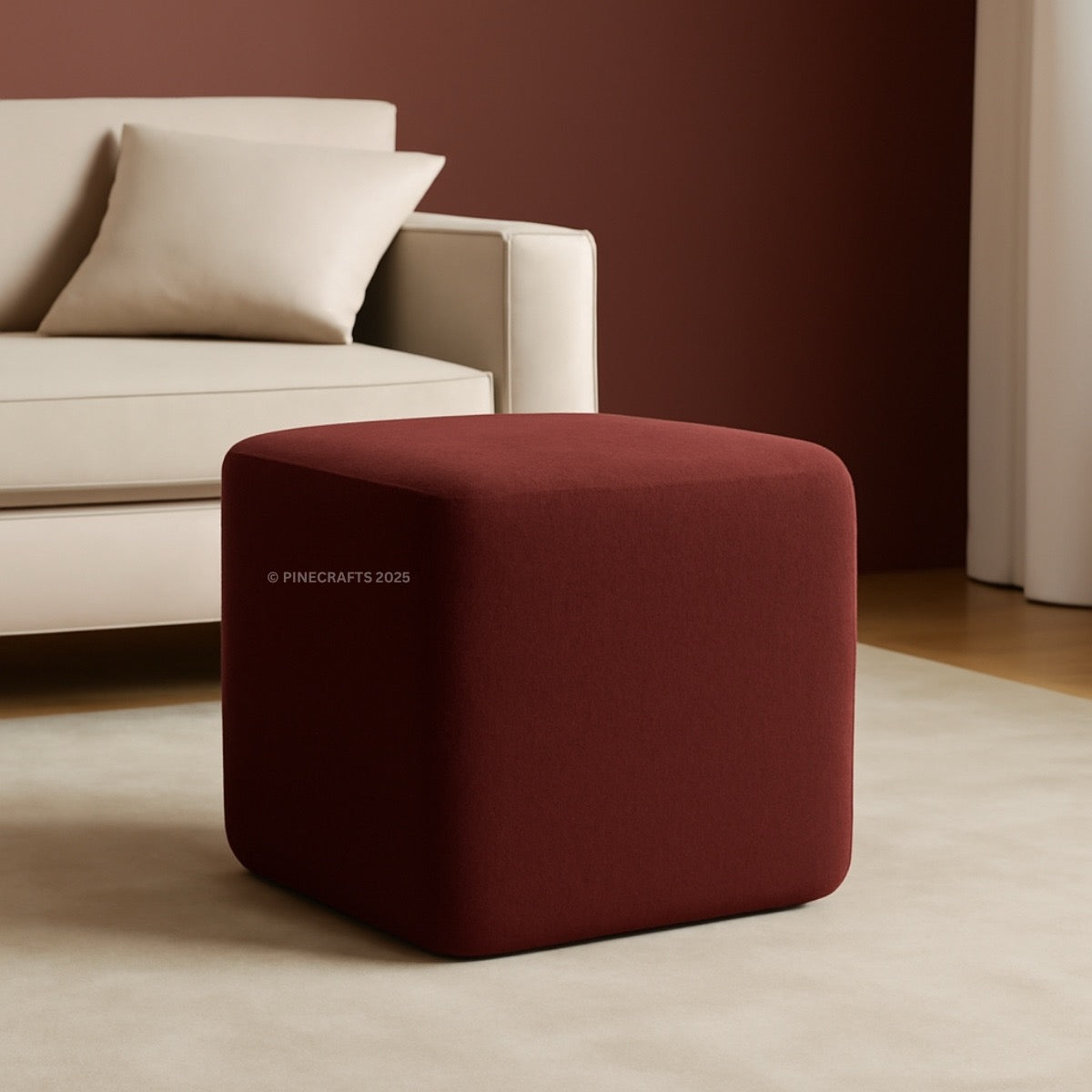 Red cube-shaped ottoman in a living room setting with a beige sofa.