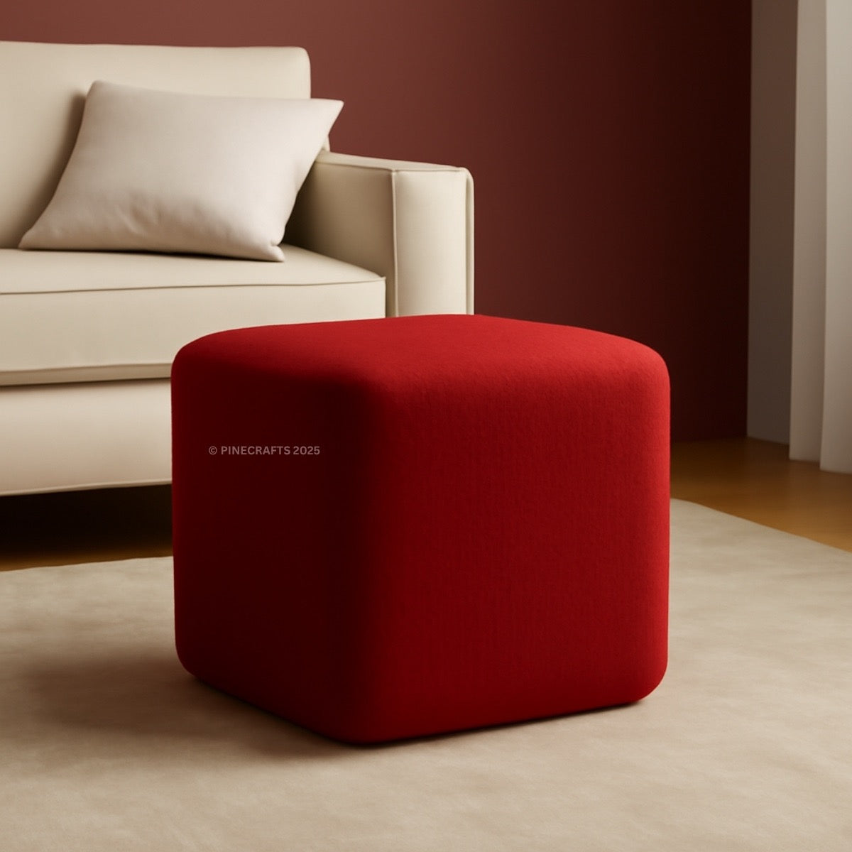 Red cube-shaped ottoman in a living room setting with a beige sofa.