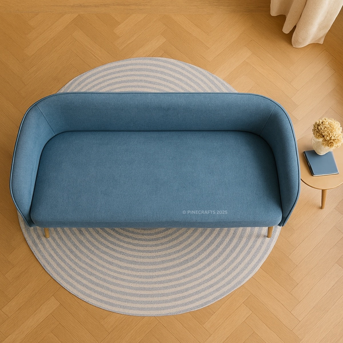Blue sofa on a round rug in a room with wooden flooring