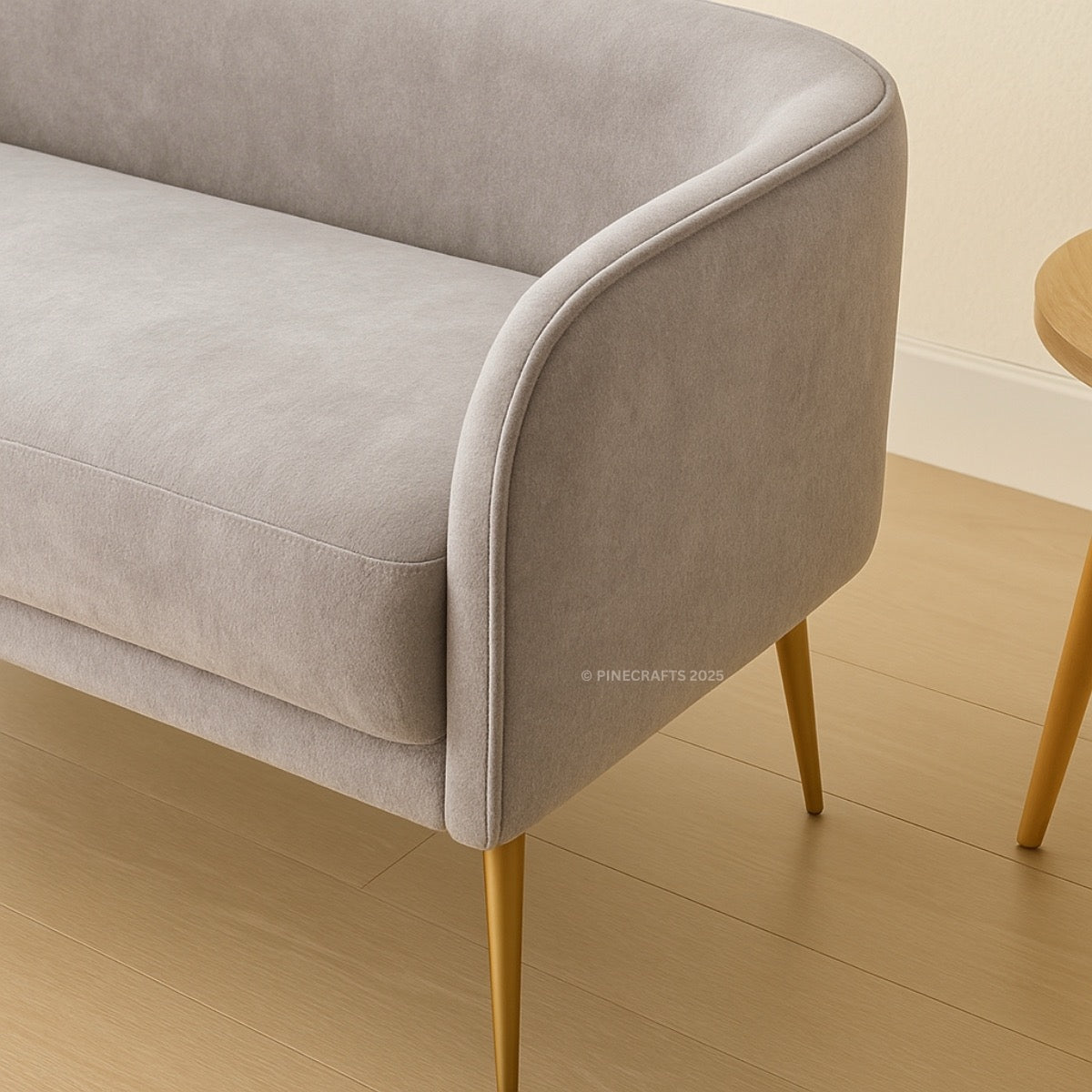 Gray upholstered bench with gold legs on a wooden floor