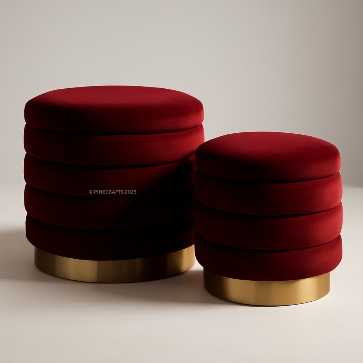 Two red stools with gold bases on a neutral background