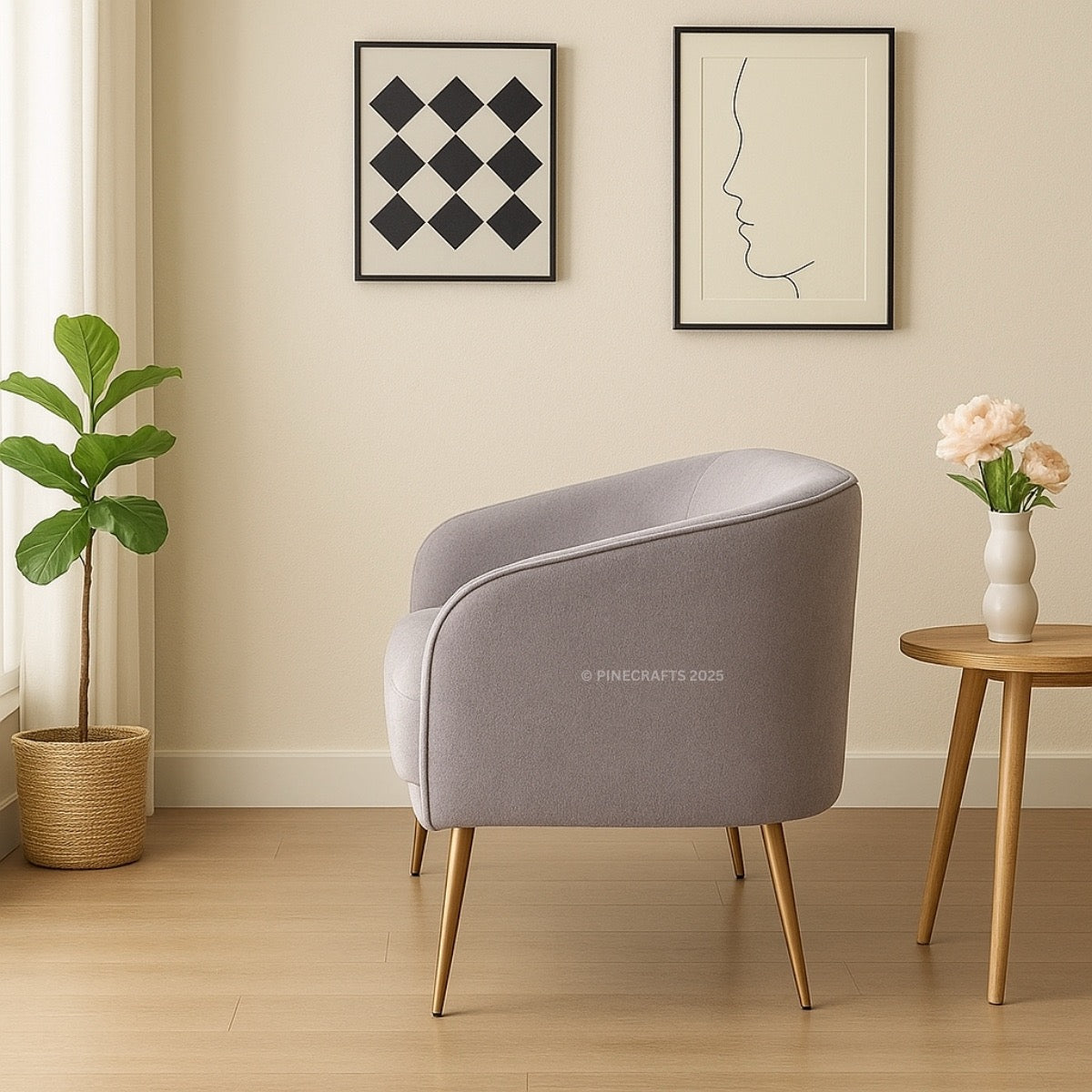 Gray armchair in a room with a plant, side table, and wall art.