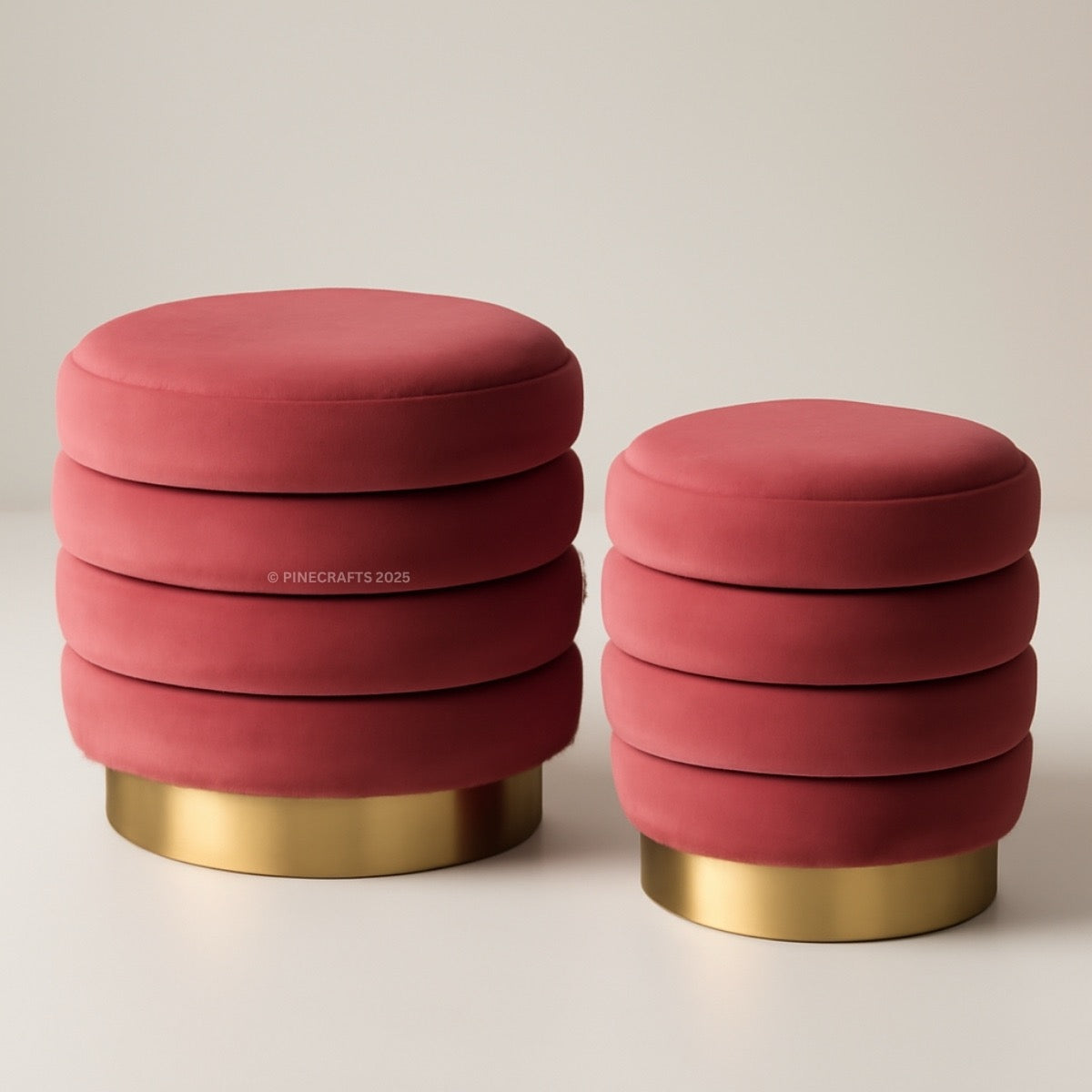 Two pink ottomans with gold bases on a beige background