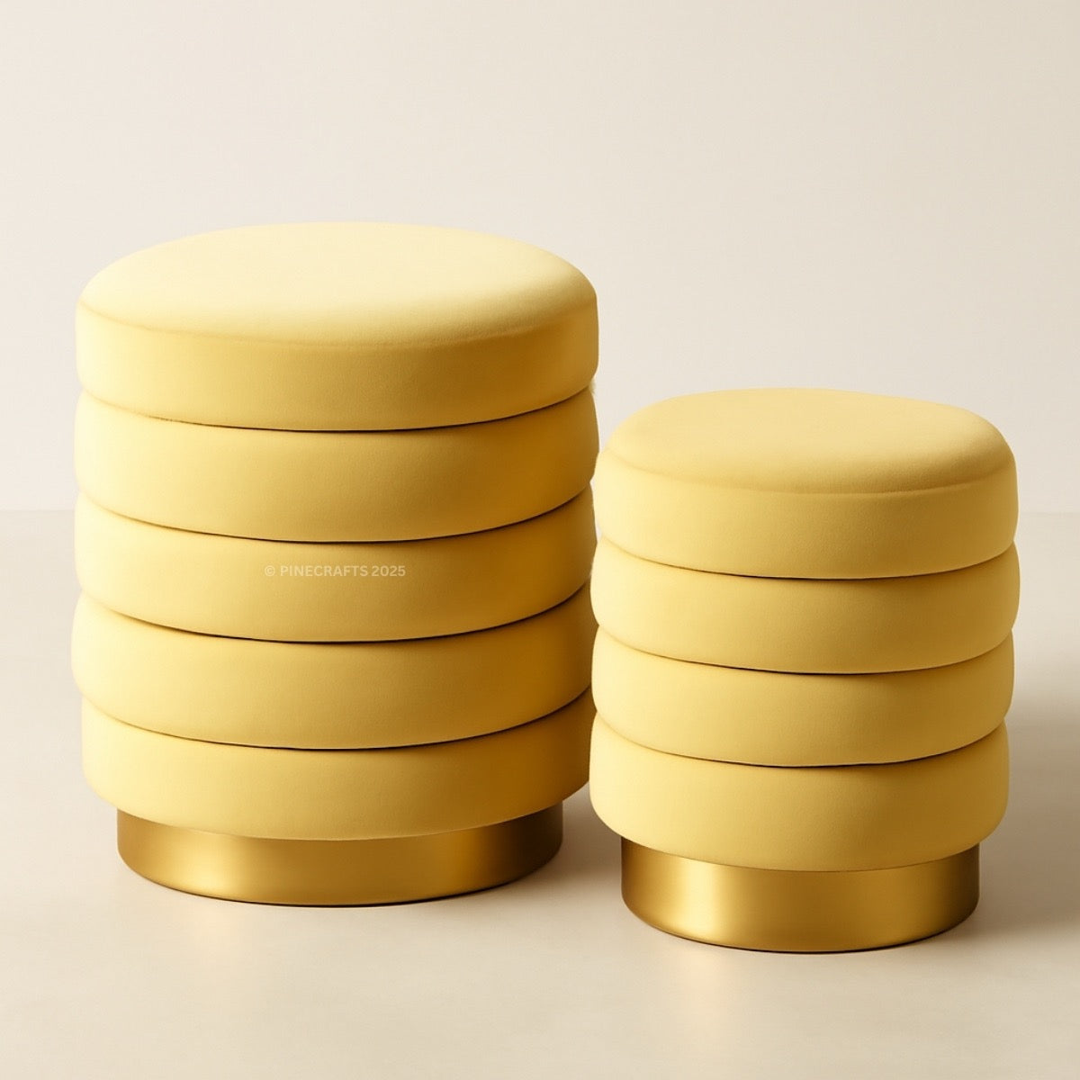 Two yellow stools with gold bases on a beige background