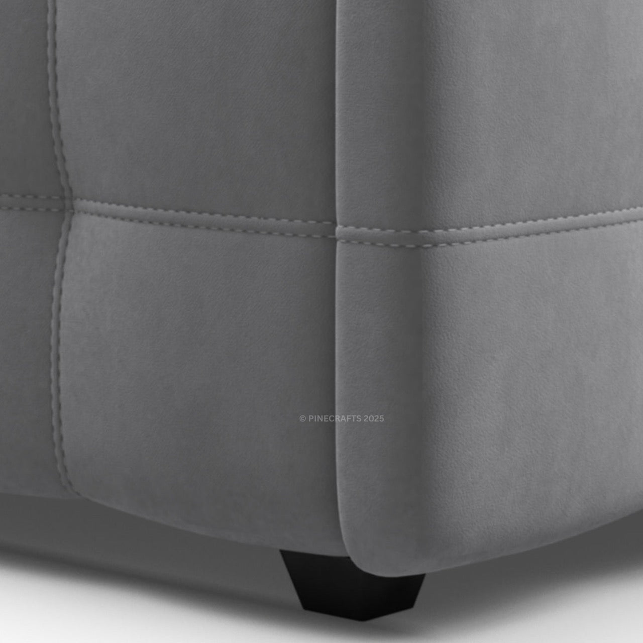 Close-up of a gray upholstered chair corner with visible stitching.