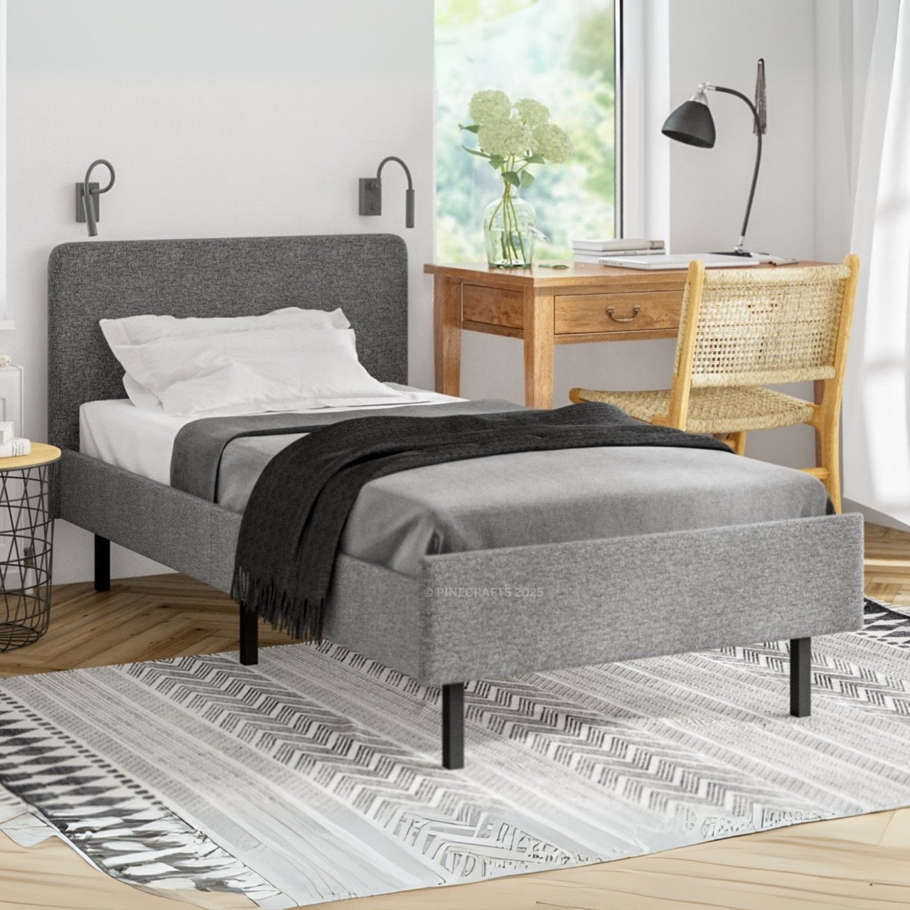 Gray upholstered bed in a bedroom with a desk and chair.