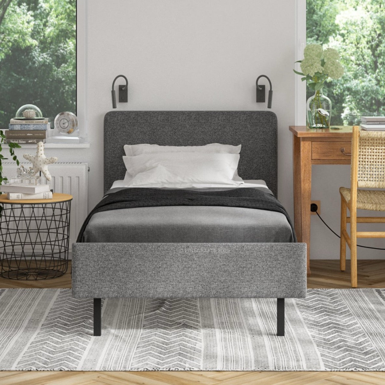 Gray upholstered bed in a room with a desk and window