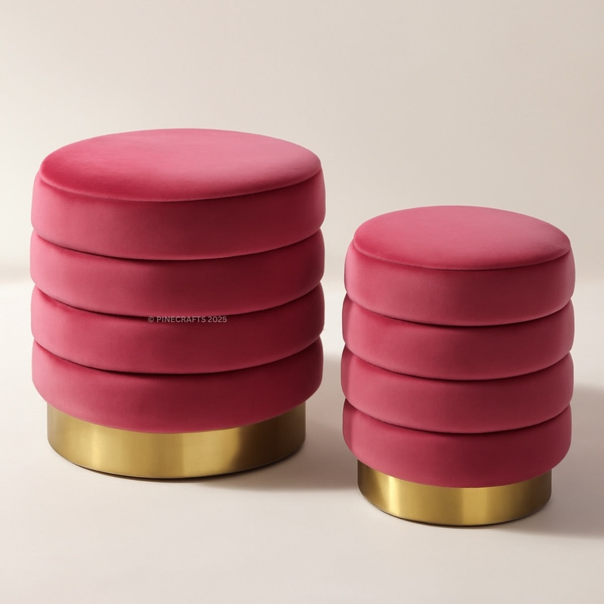 Two pink ottomans with gold bases on a beige background