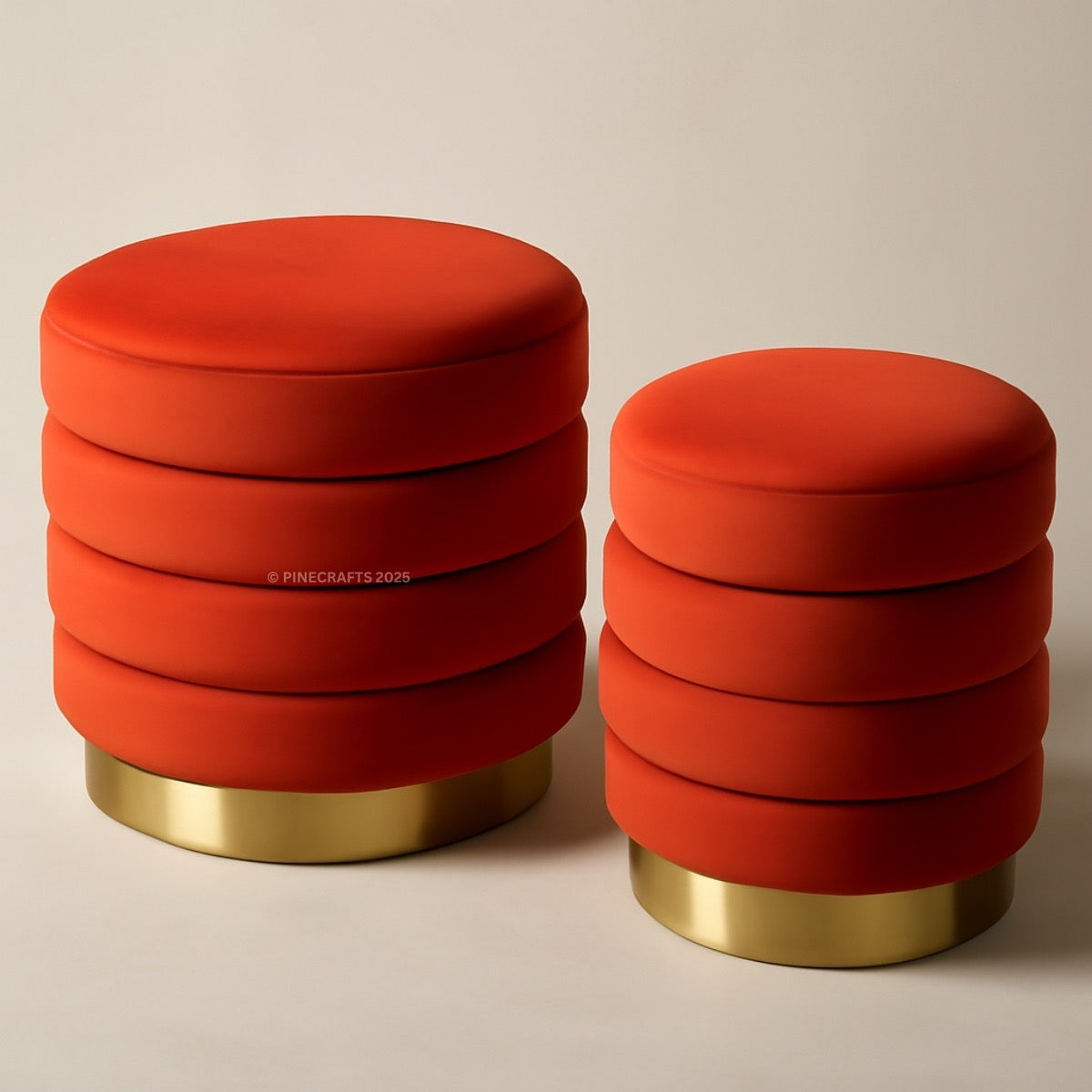 Two red ottomans with gold bases on a beige background