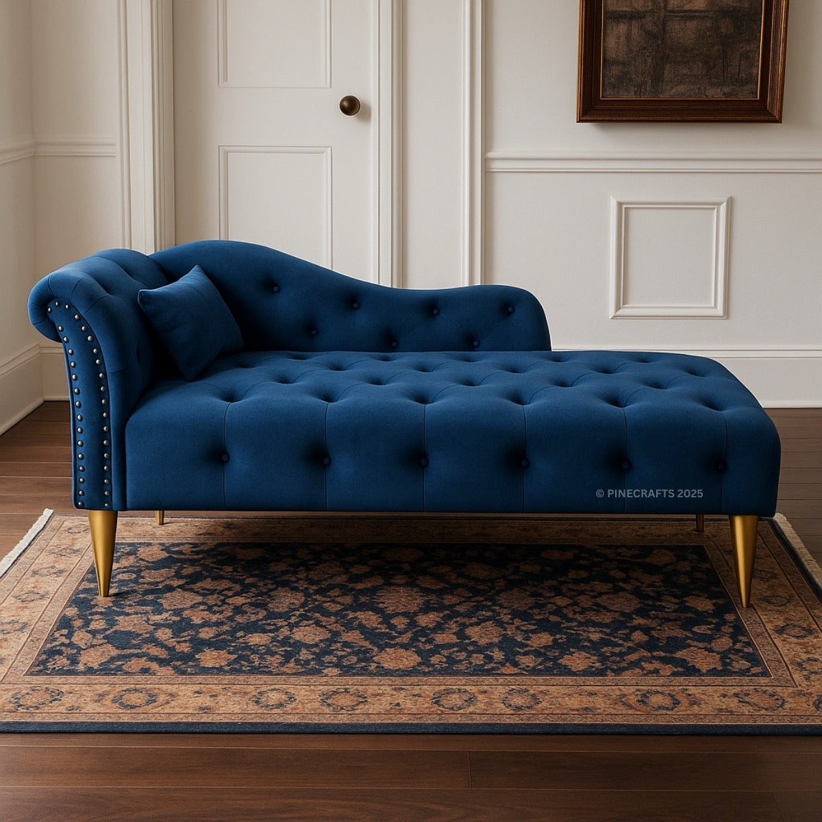 Blue tufted sofa with gold legs in a room with white paneled walls and a patterned rug.