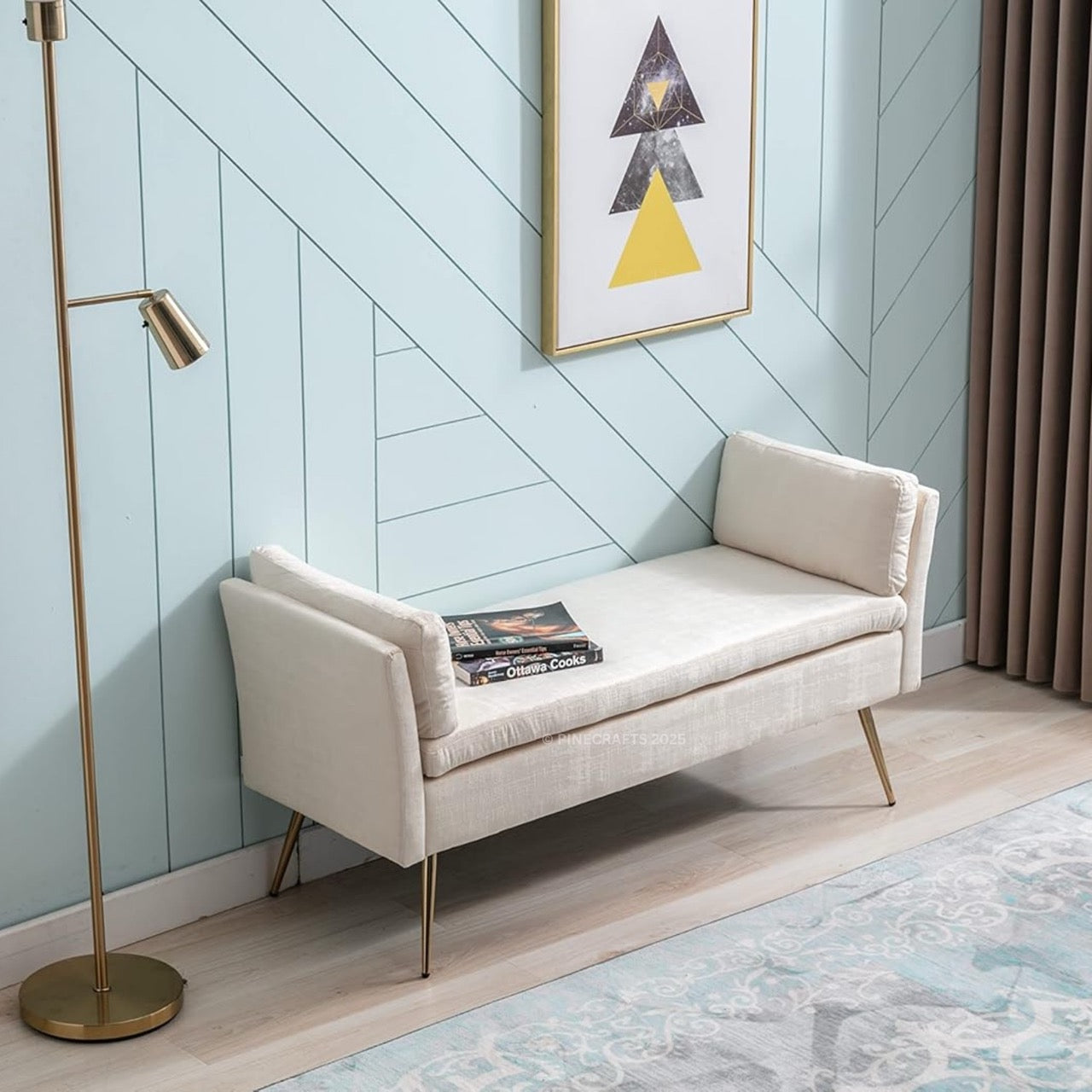 Beige bench against a light blue wall with a gold floor lamp and abstract art.