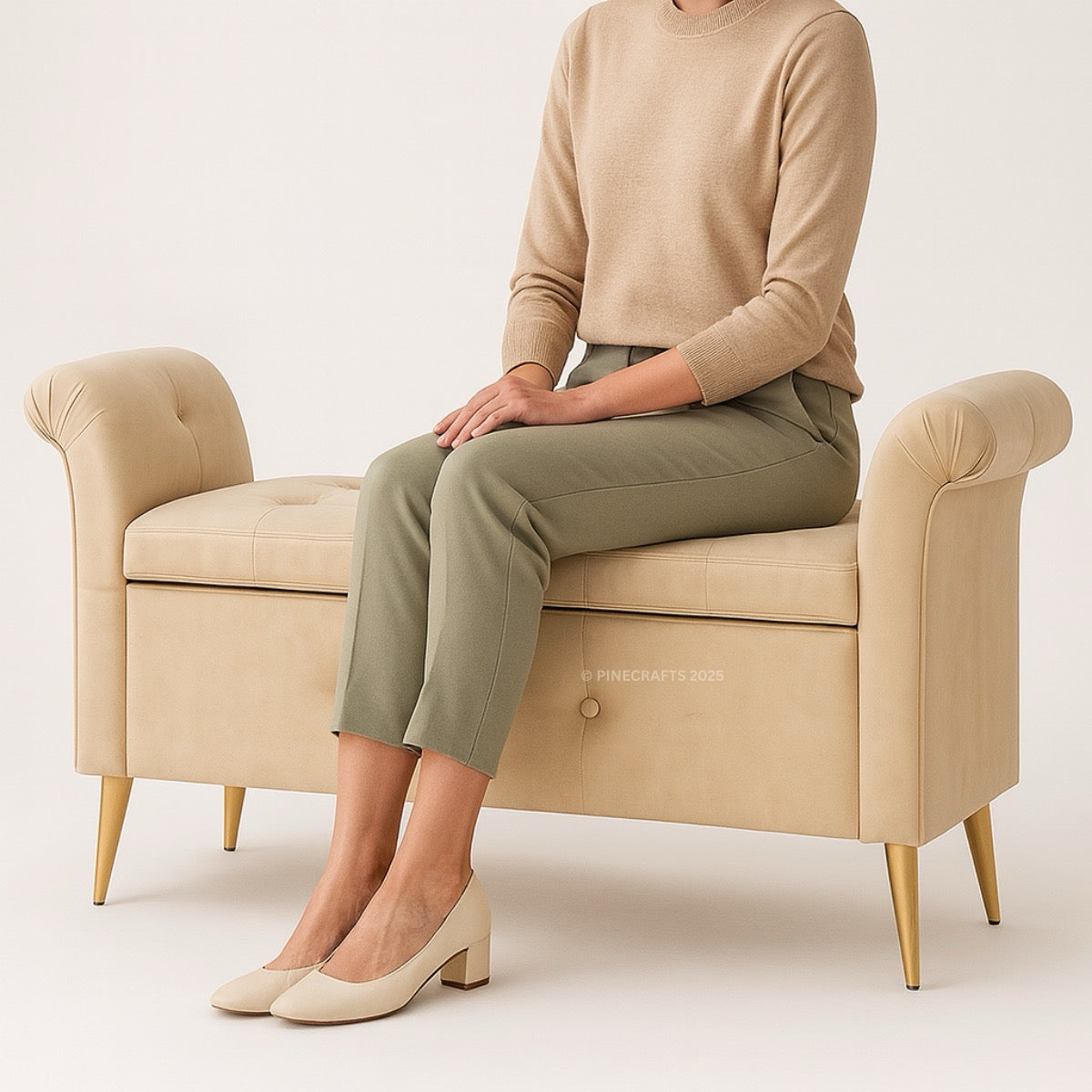Person sitting on a beige armchair wearing a beige sweater and green pants.