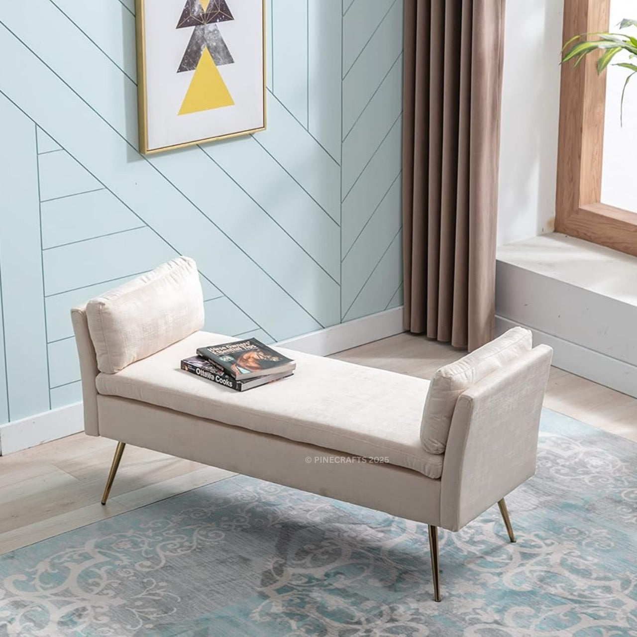 Beige bench with books on a patterned rug in a room with a chevron-patterned wall.