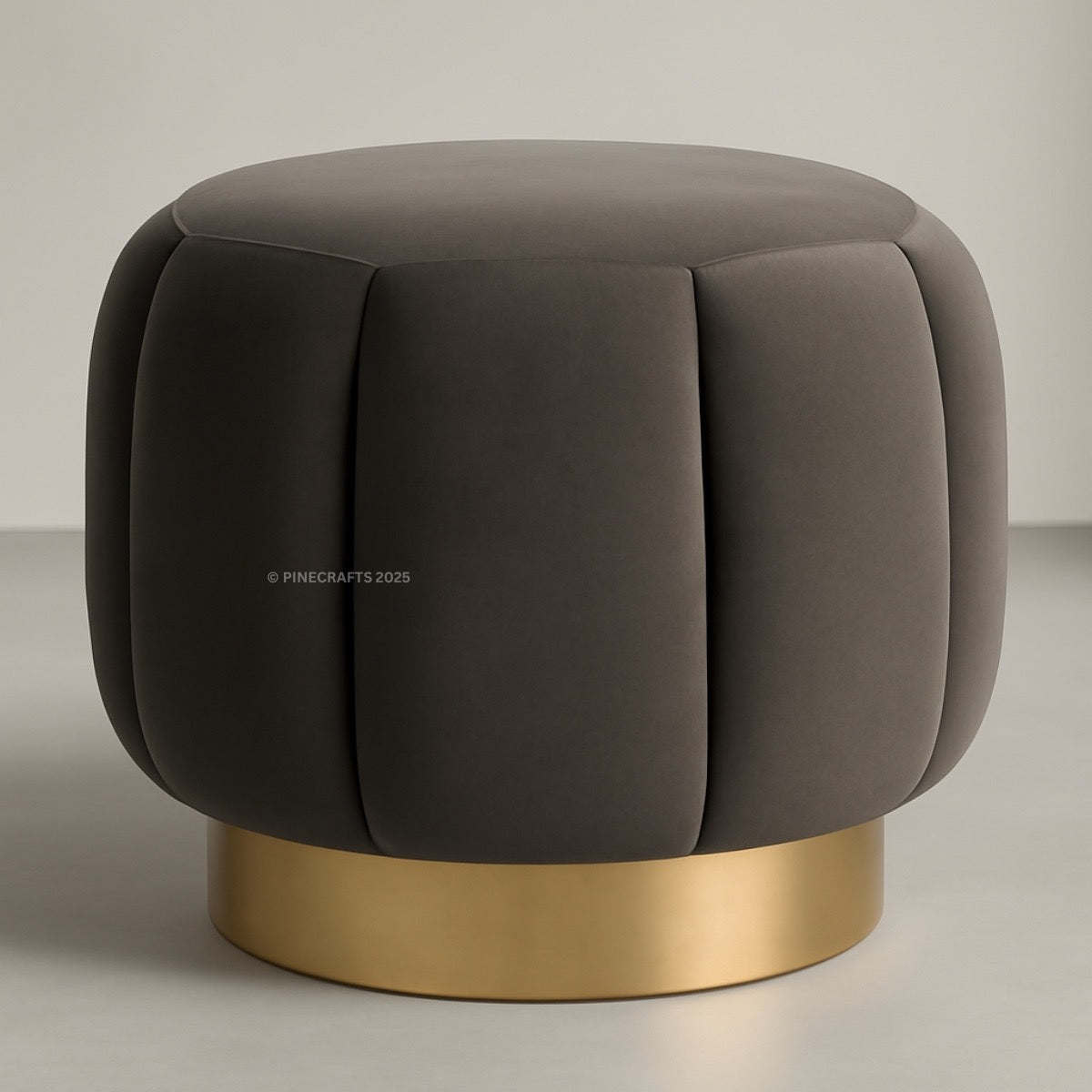 Gray cushioned stool with a gold base on a neutral background