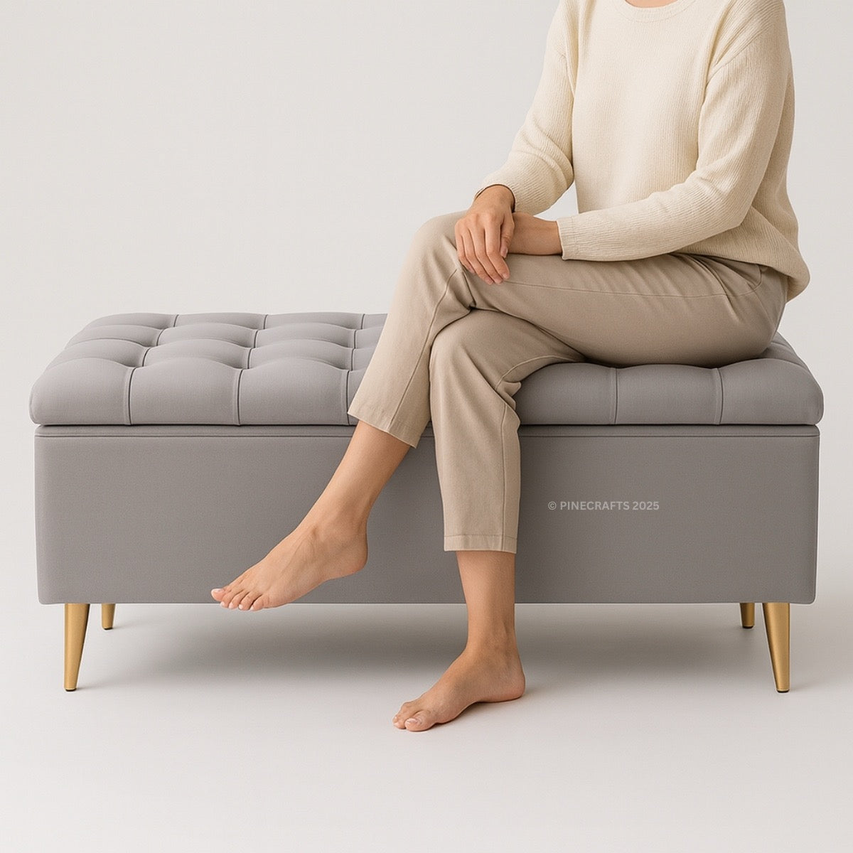 Person sitting on a gray tufted bench with 'Pinecrafts' branding.