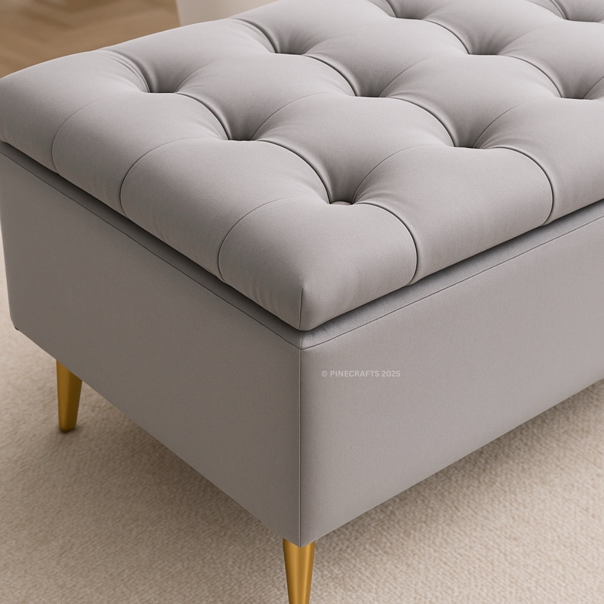 Gray tufted ottoman with gold legs on a beige carpet