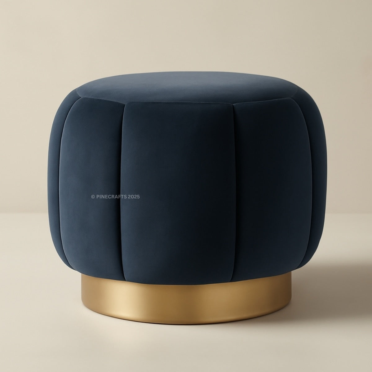 Blue velvet ottoman with a gold base on a beige background