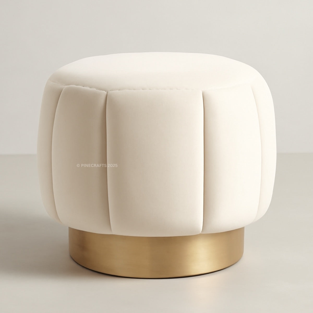 Beige ottoman with a gold base on a light gray background