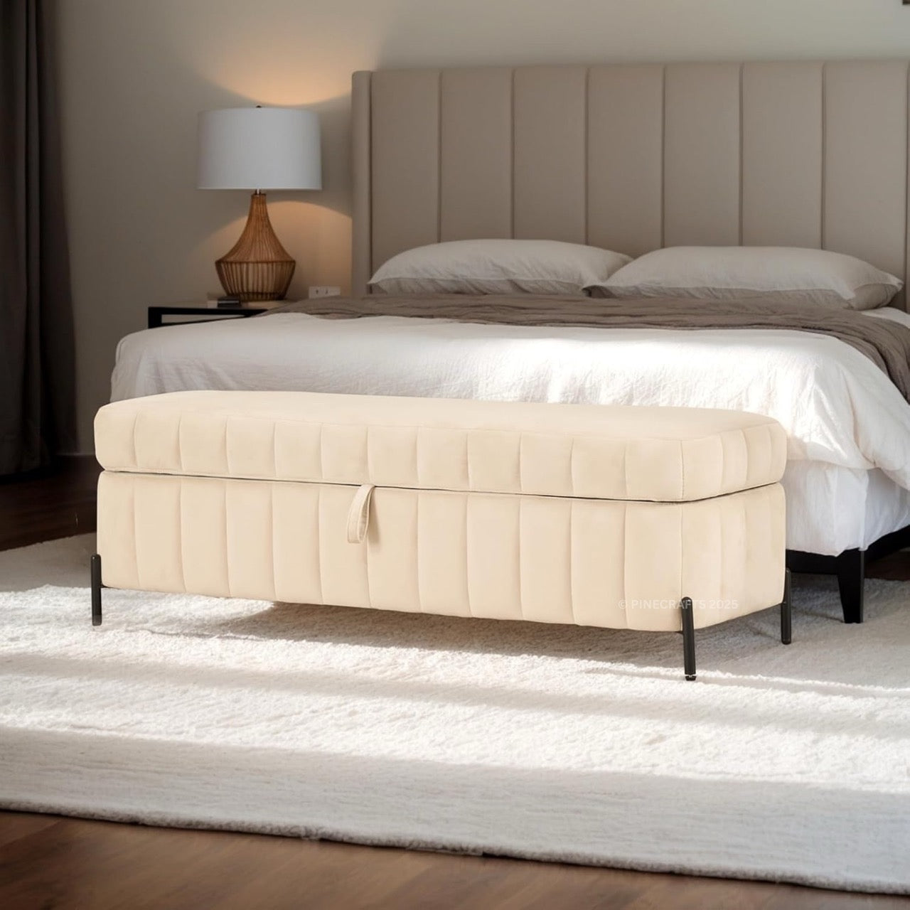 Beige ottoman in front of a bed with a neutral color scheme