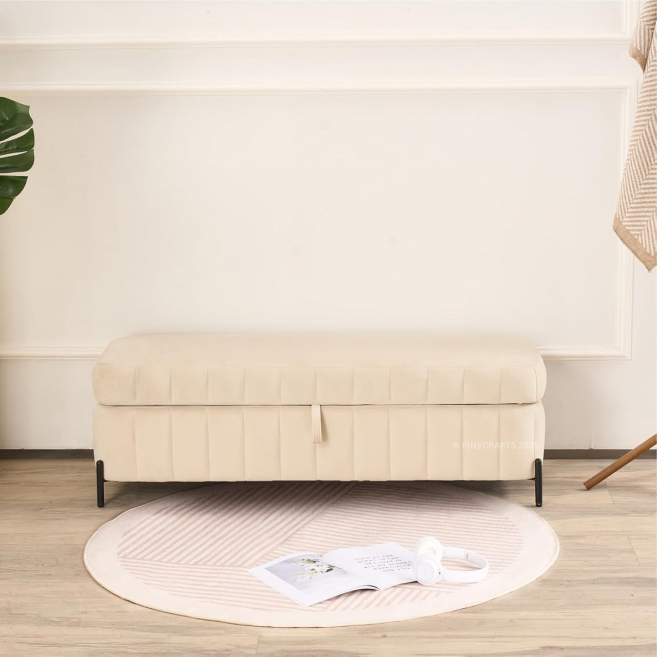 Beige ottoman in a room with a plant and rug