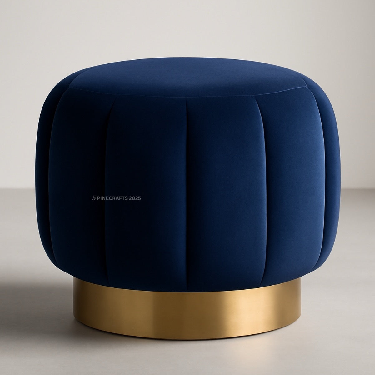Blue ottoman with a gold base on a neutral background