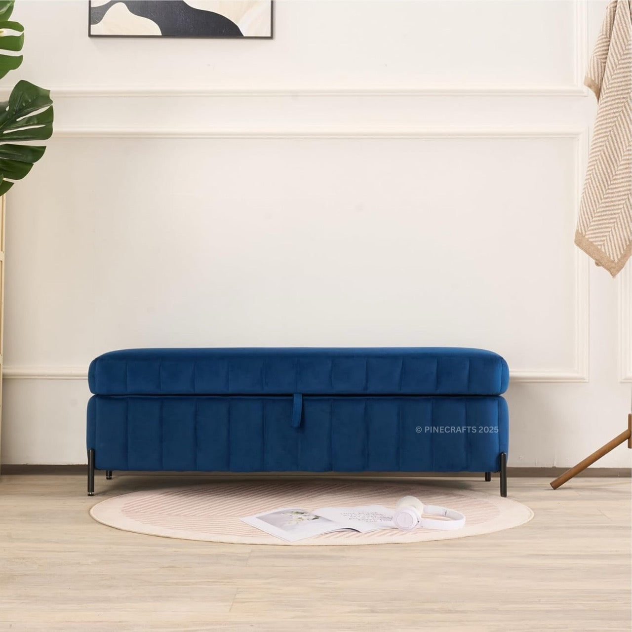 Blue sofa in a room with a white wall and wooden floor.