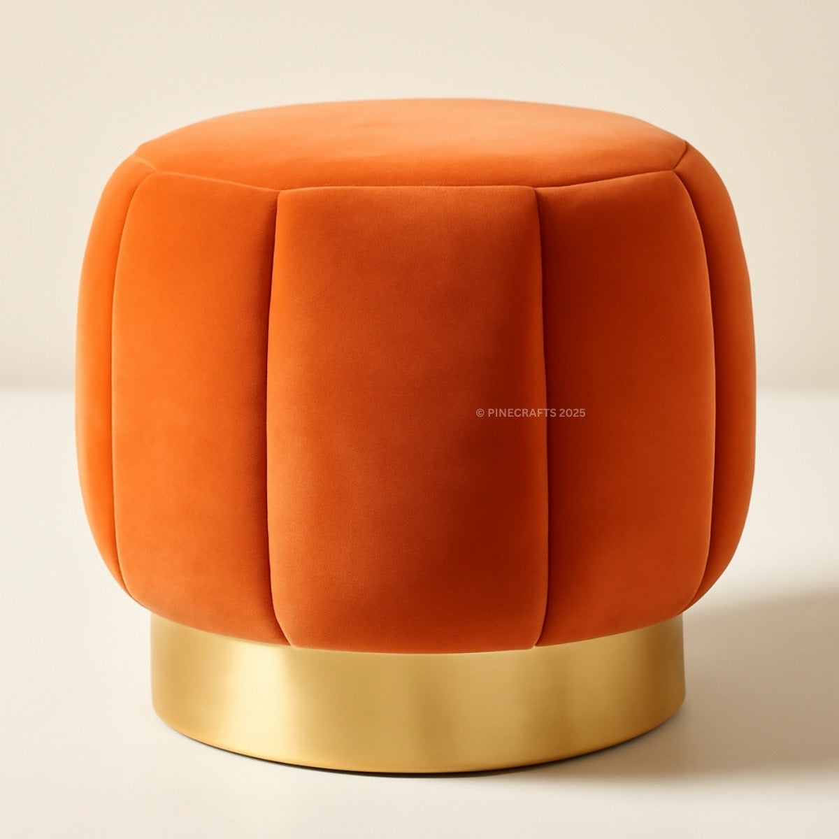 Orange velvet ottoman with a gold base on a beige background