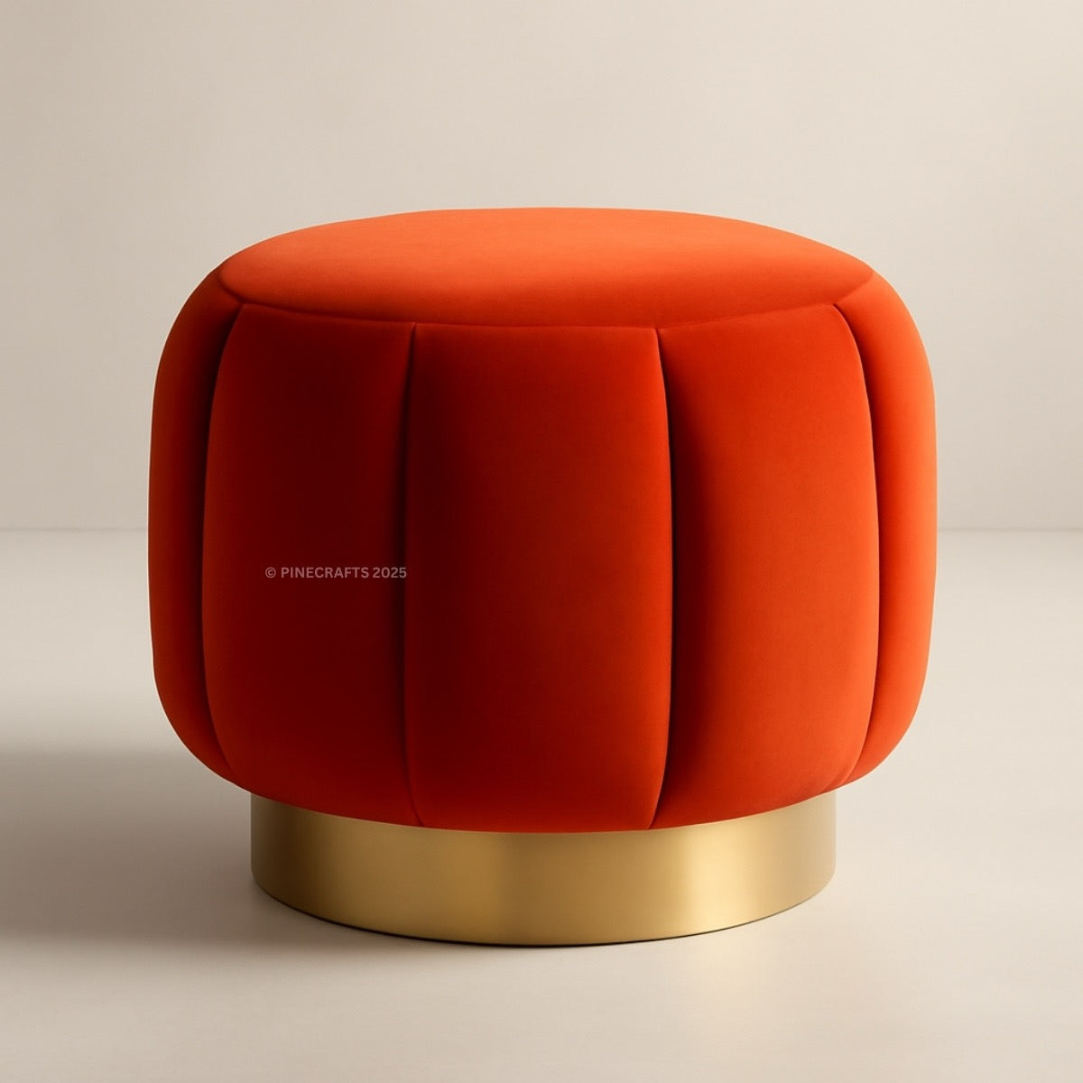 Orange velvet ottoman with a gold base on a beige background