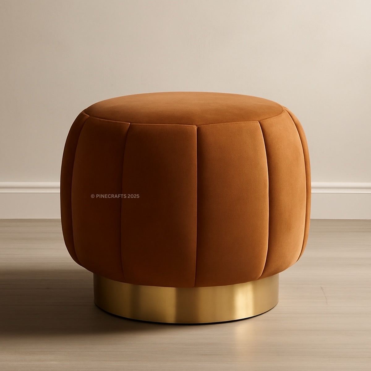 Brown ottoman with gold base on a wooden floor