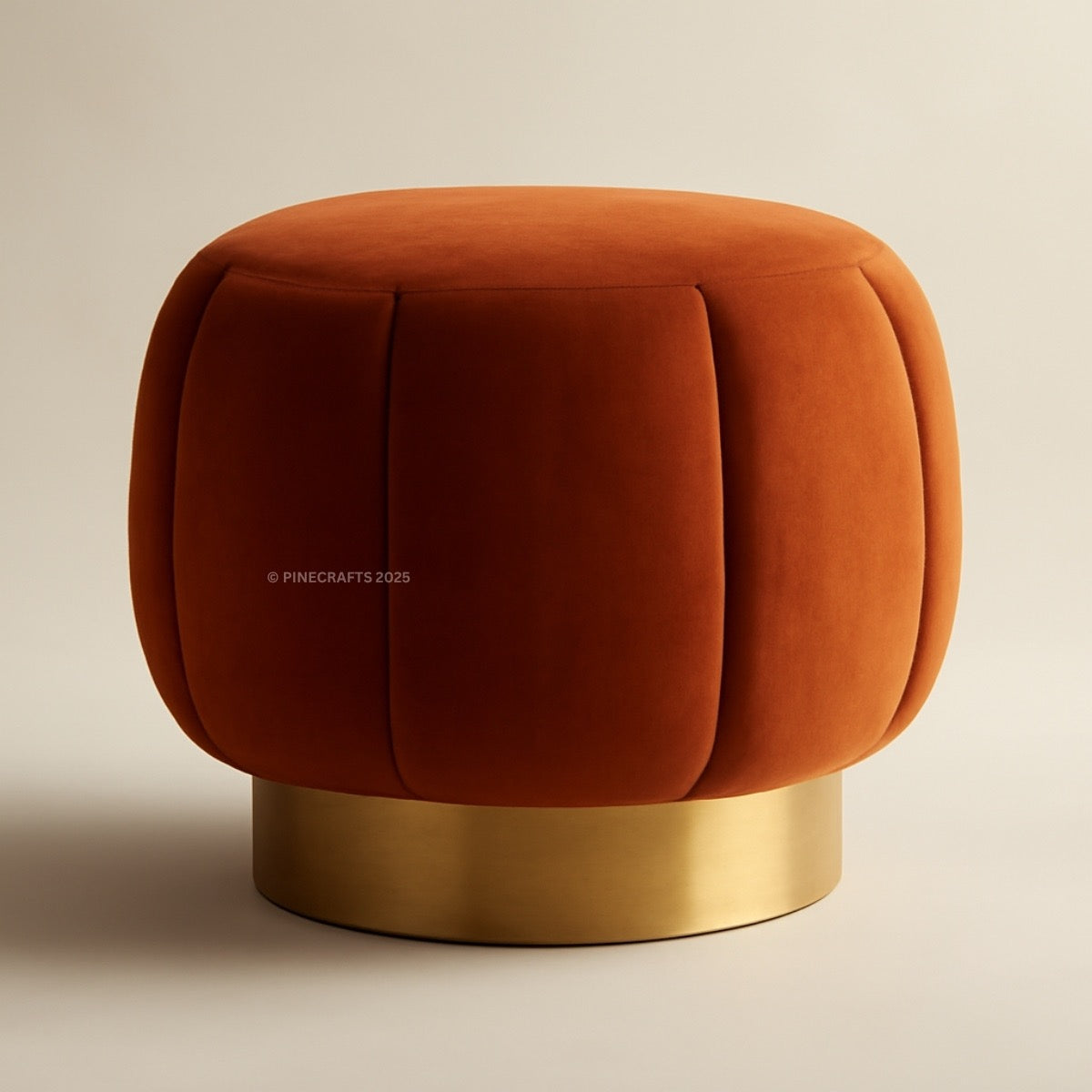 Orange velvet ottoman with a gold base on a beige background