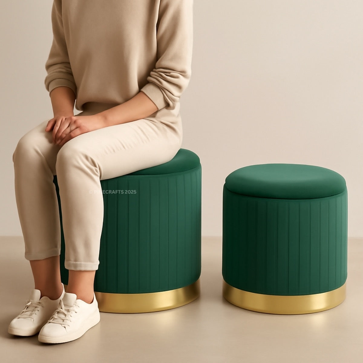 Person sitting on a green ottoman with gold base, next to another similar ottoman.