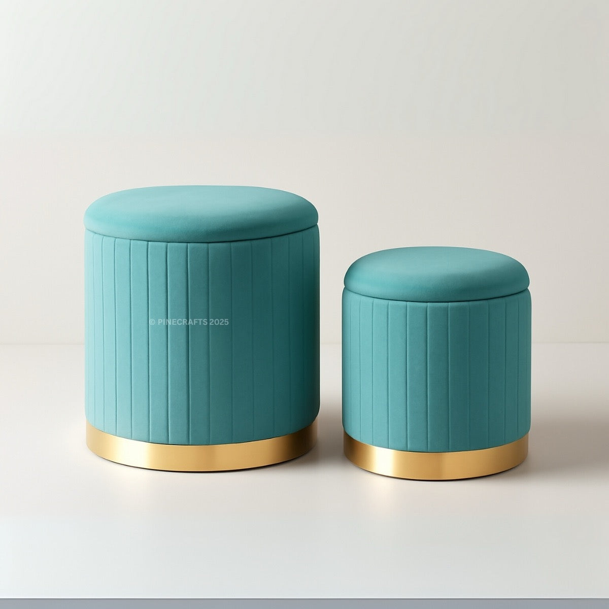 Two teal ottomans with gold bases on a light gray background