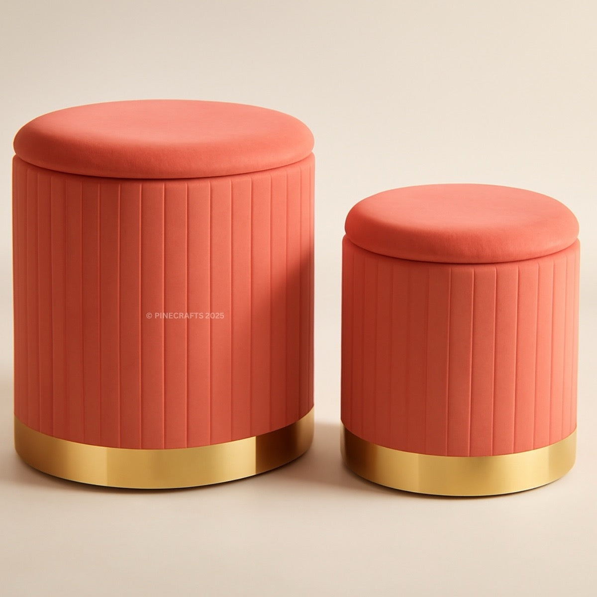 Two coral-colored ottomans with gold bases on a beige background