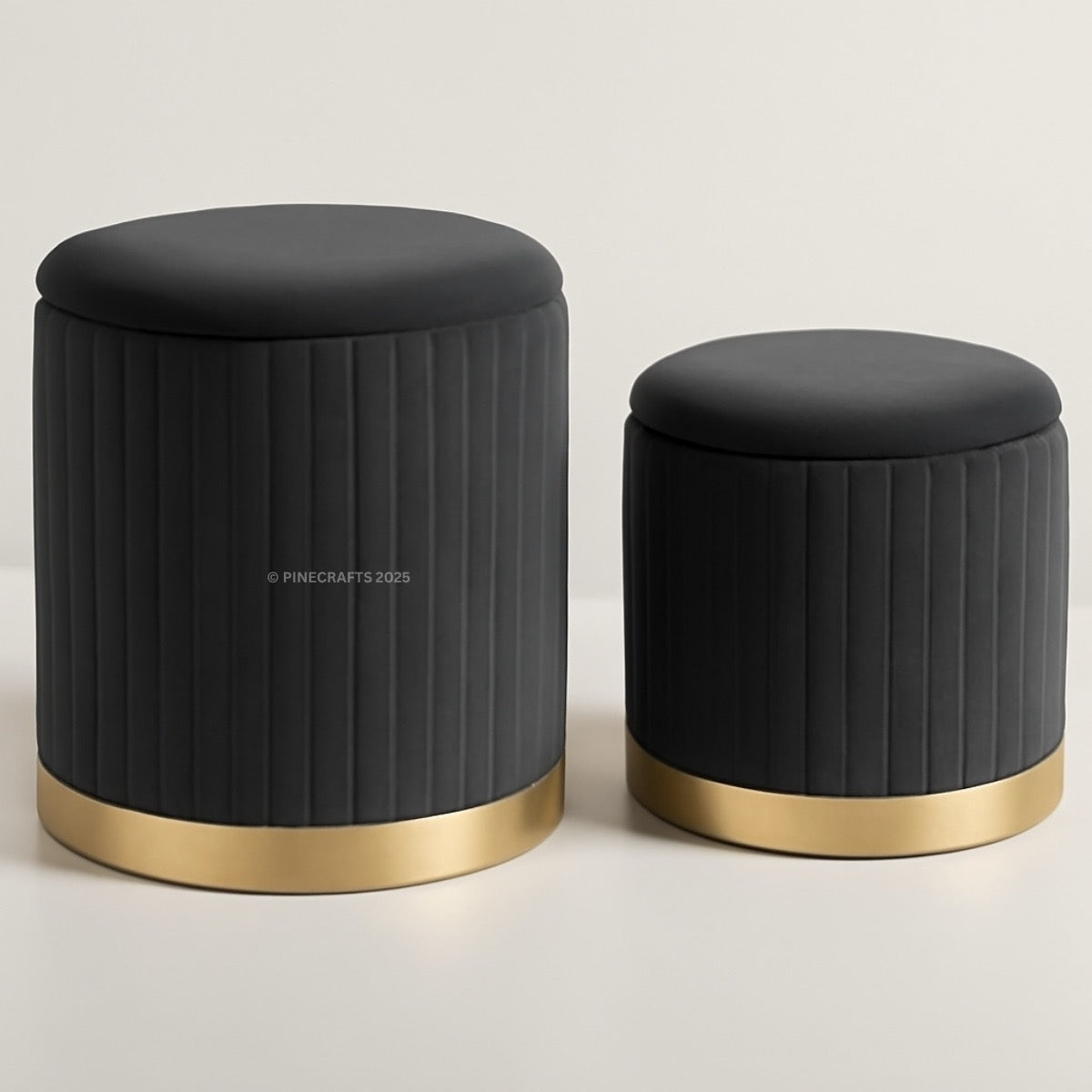 Two black stools with gold bases on a light gray background
