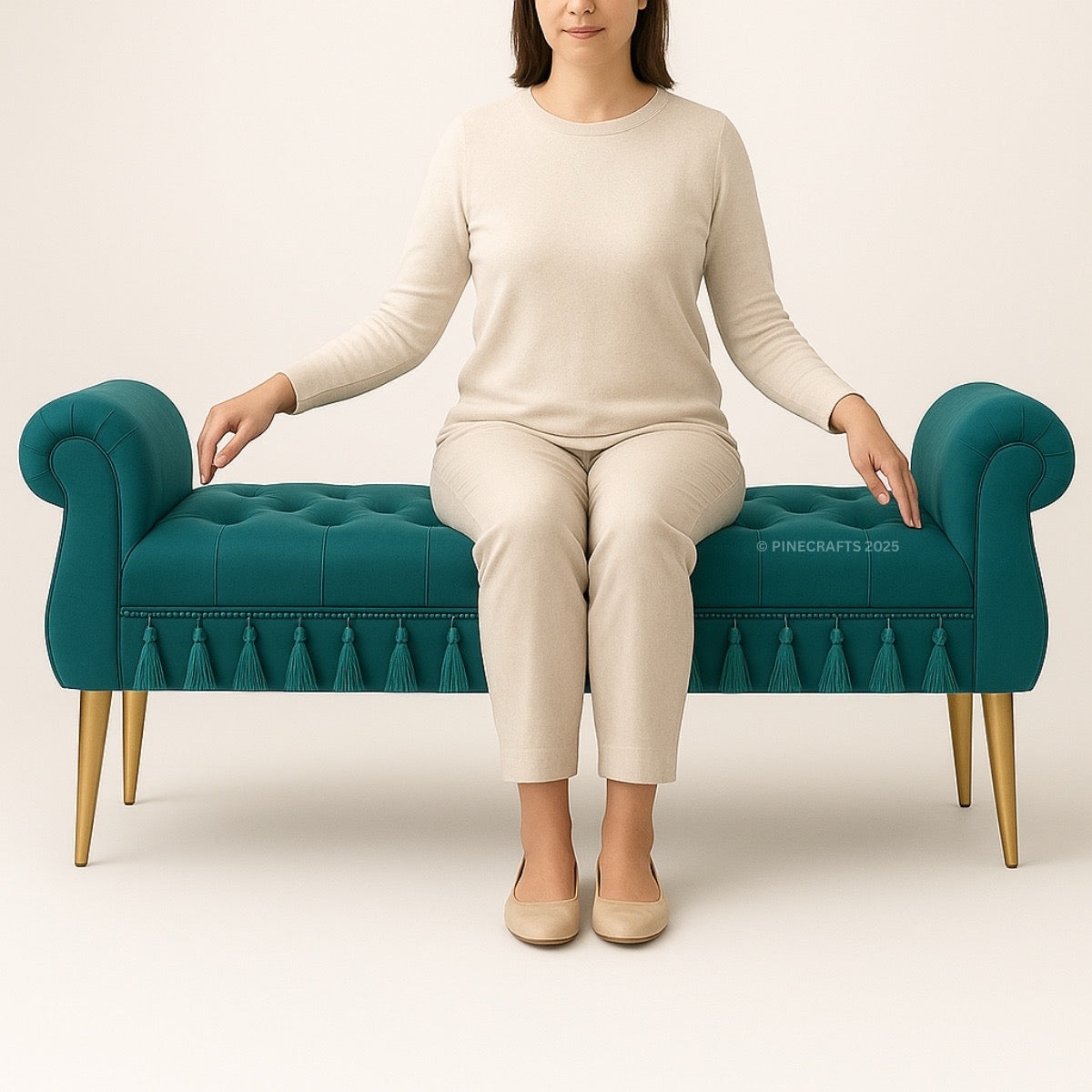 Person sitting on a teal bench with tufted design and gold legs against a beige background