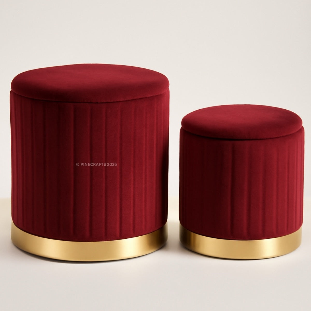 Two red ottomans with gold bases on a light beige background