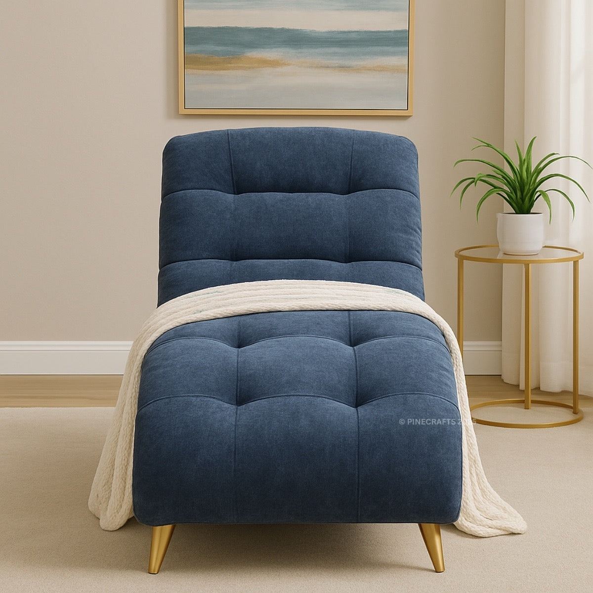 Blue armchair with a white blanket in a room with a painting and plant on a side table.
