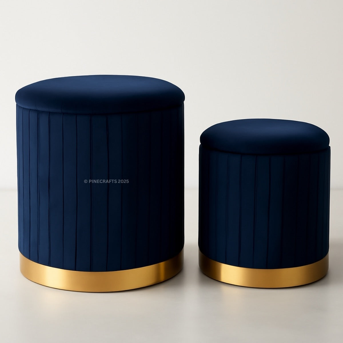 Two navy blue stools with gold bases on a light background