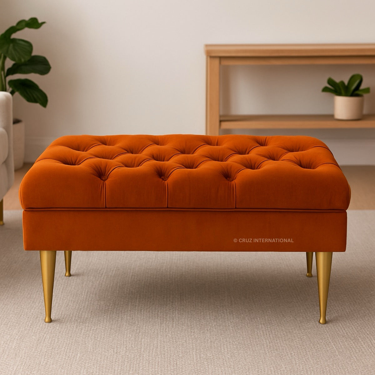 Orange tufted bench with gold legs in a room setting