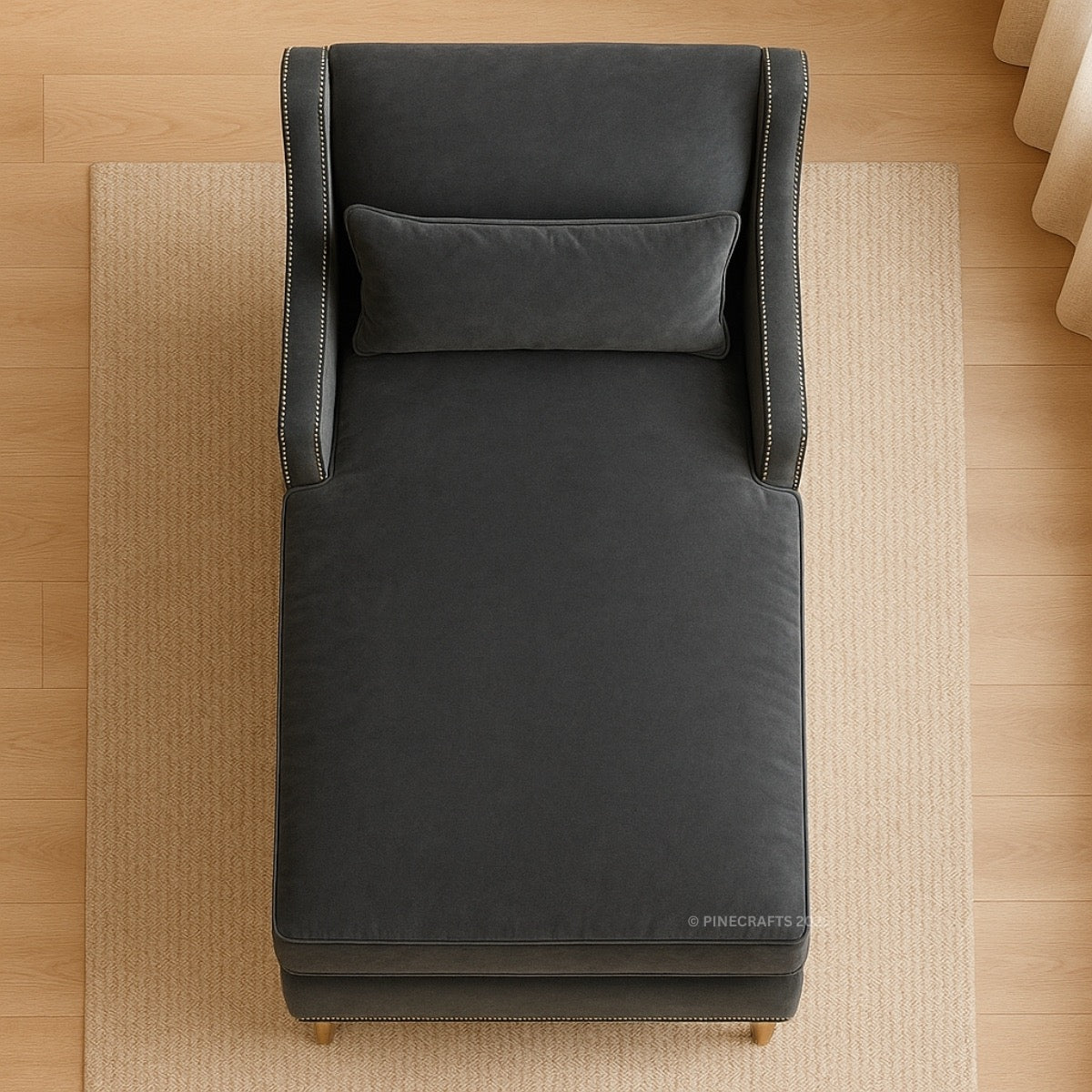 Dark gray upholstered chair with a pillow on a wooden floor.
