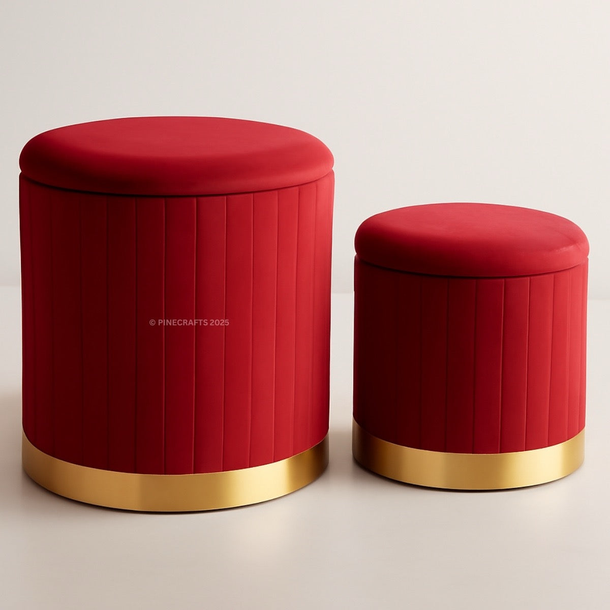 Two red ottomans with gold bases on a light background