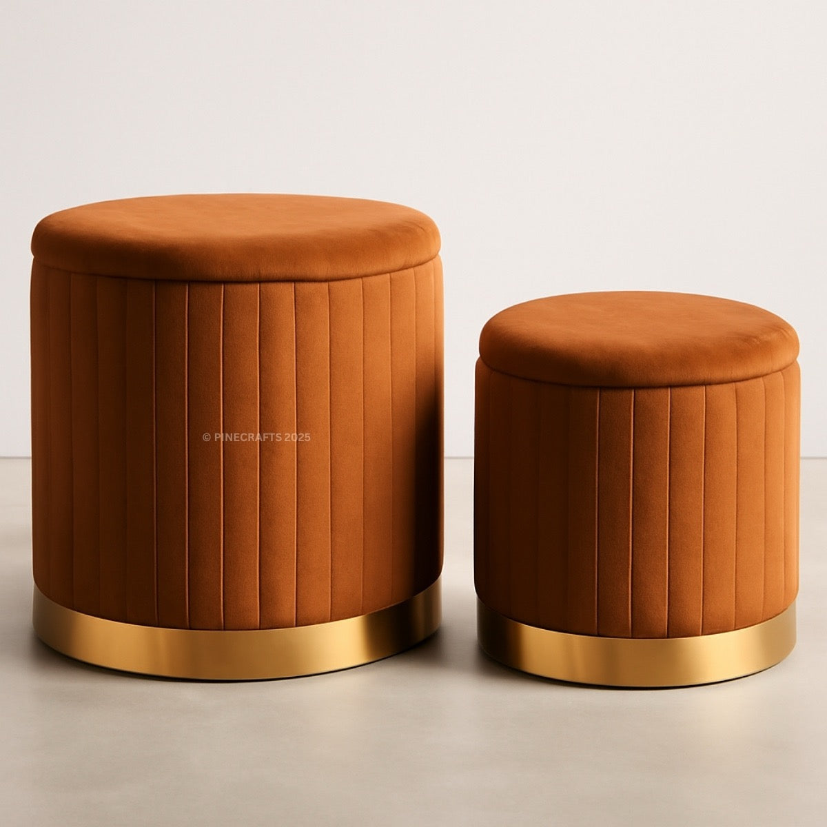 Two orange stools with gold bases on a light background