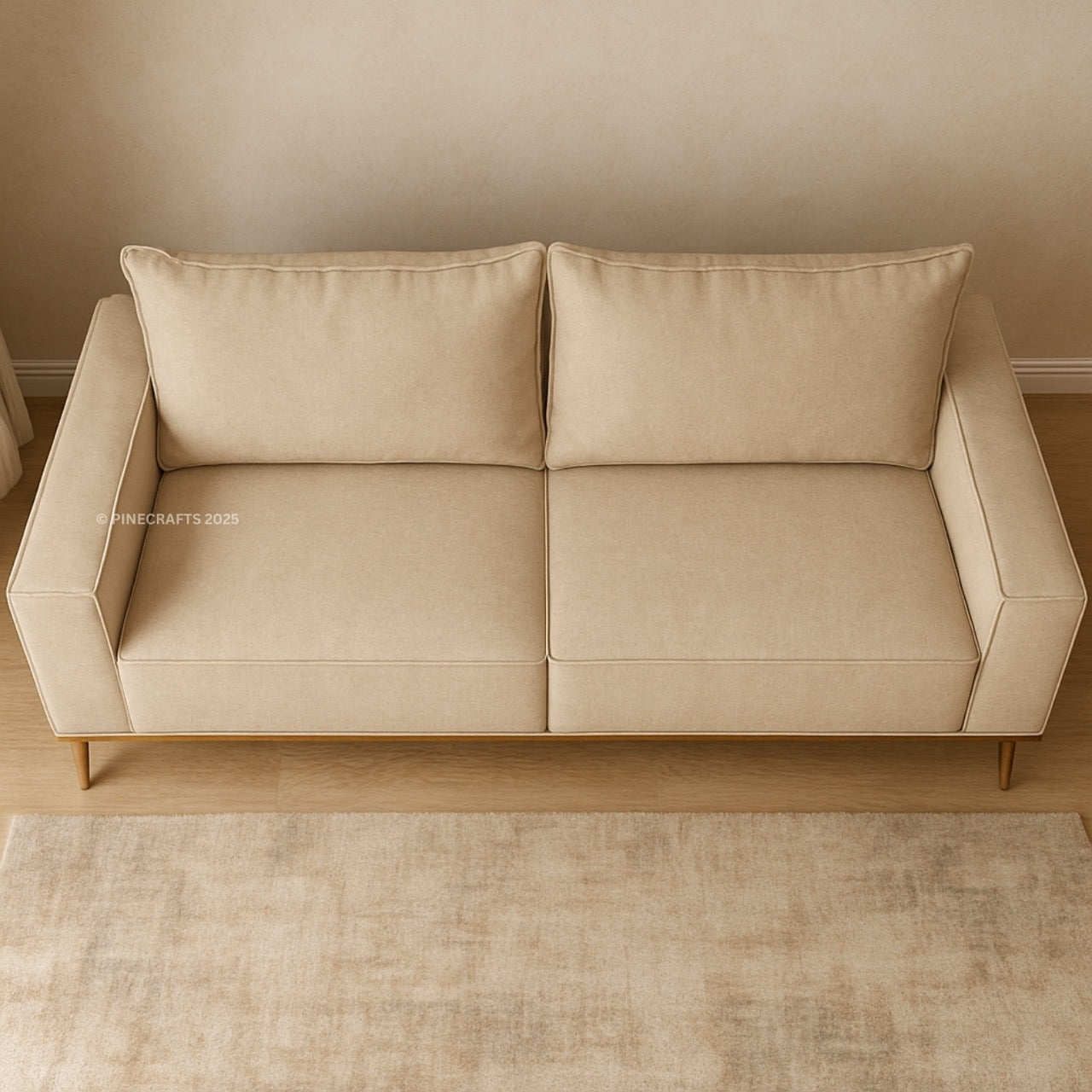 Beige sofa against a beige wall with a light brown rug on the floor.