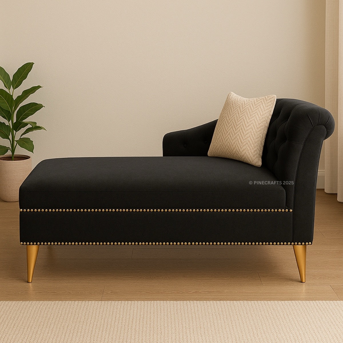Black chaise lounge with gold legs and a beige pillow in a room setting.