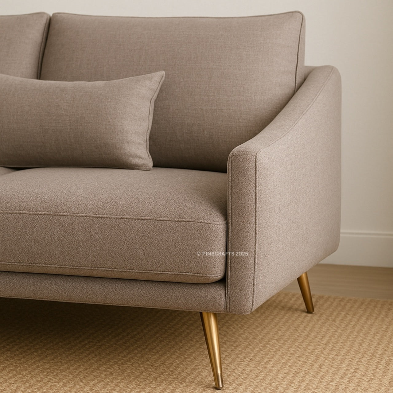 Beige sofa with gold legs on a carpeted floor.