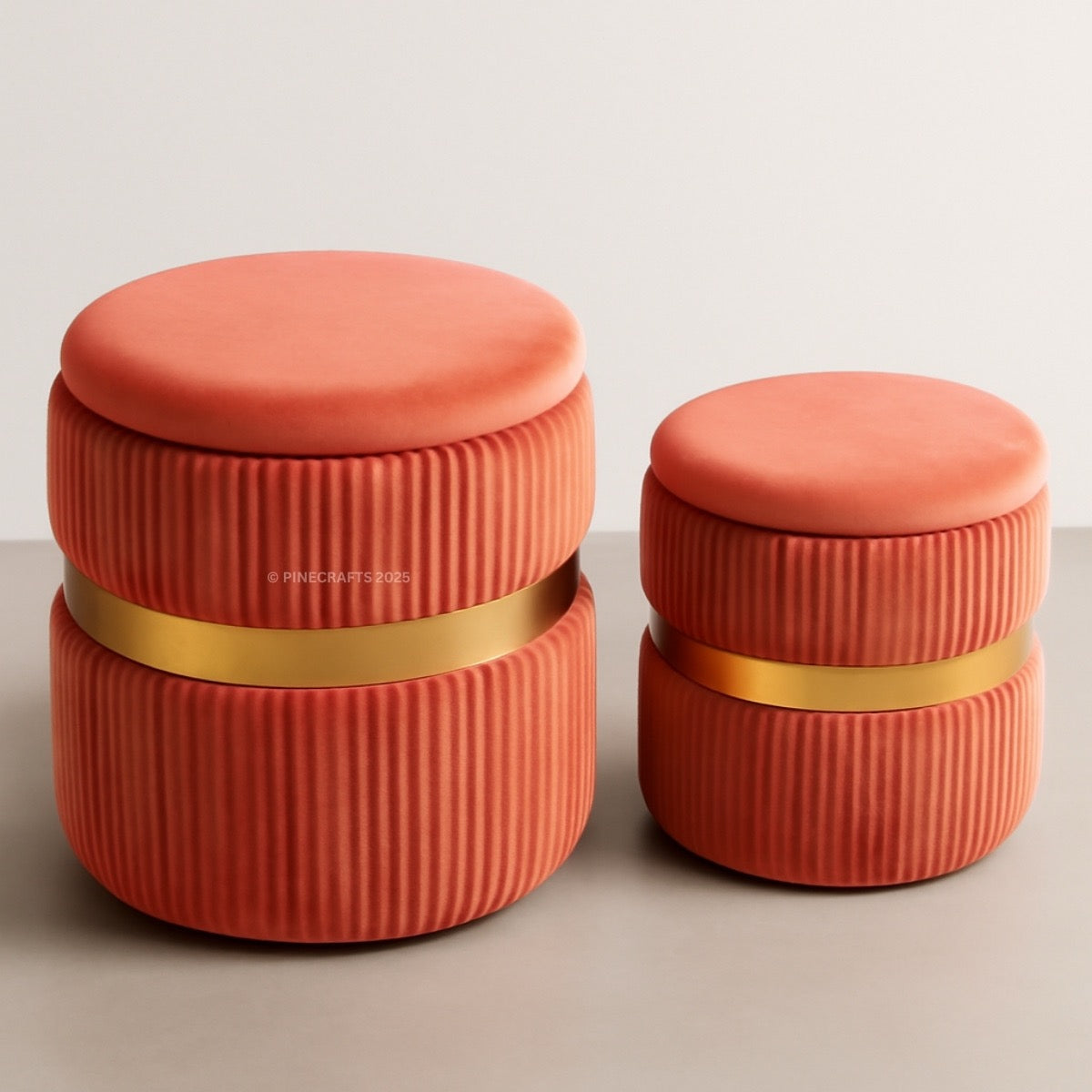 Two coral-colored cylindrical containers with gold bands on a light gray background