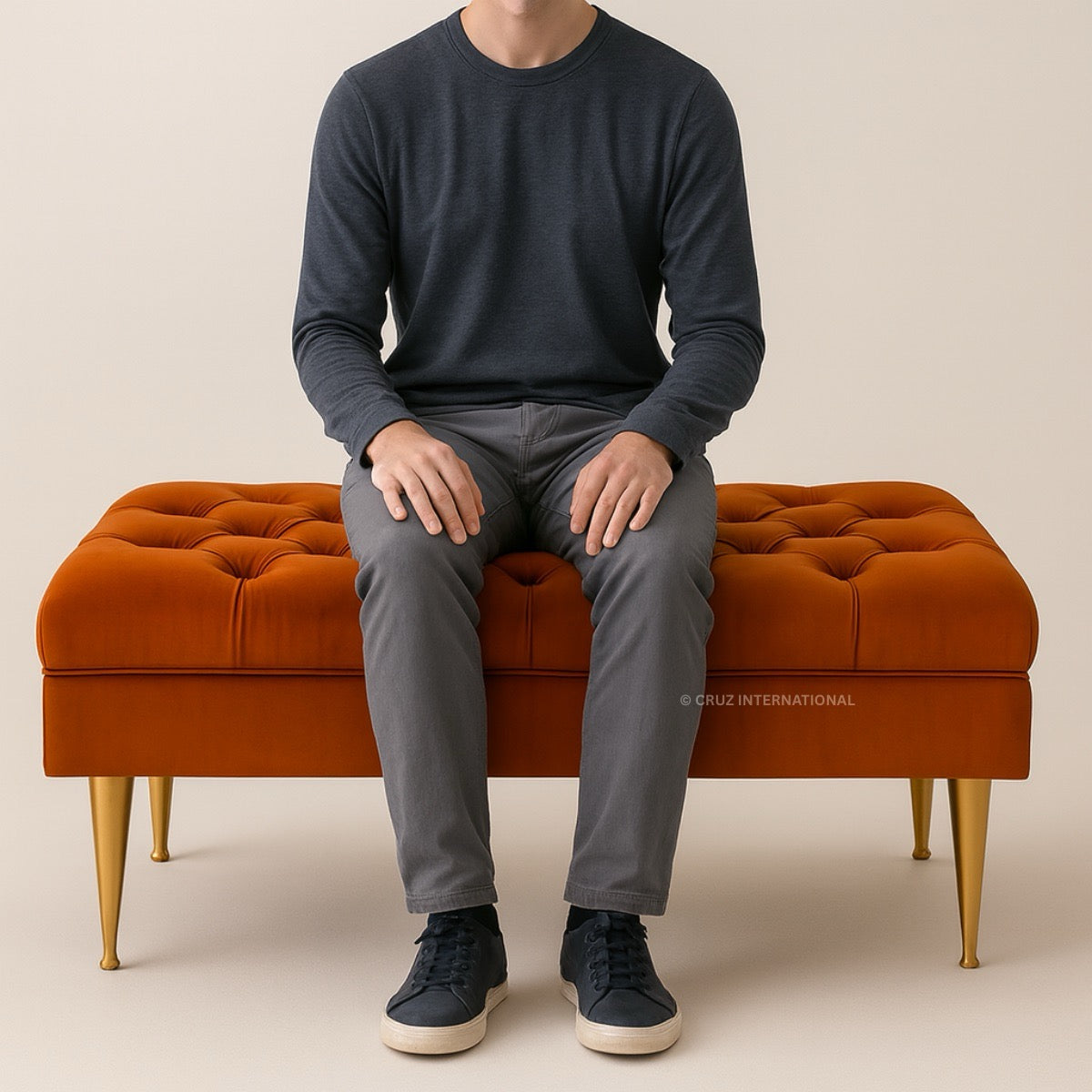 Person sitting on a brown ottoman with a neutral background