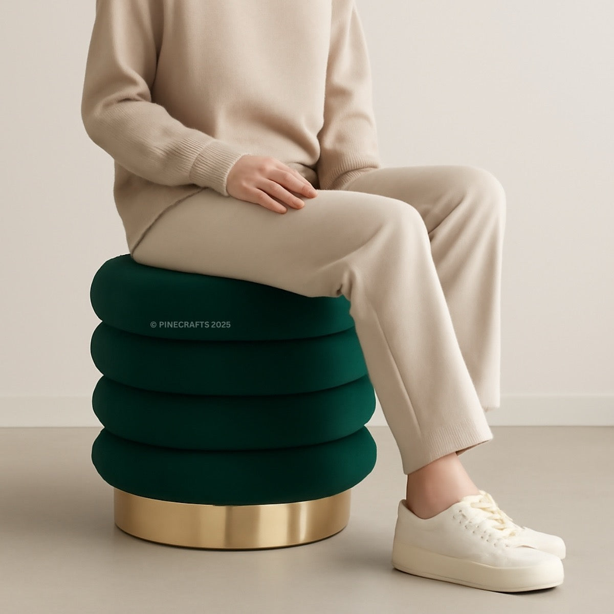 Person sitting on a green and gold stool with a neutral background